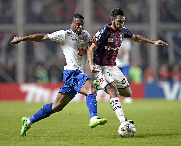 Julio Baptista (esq.), do Cruzeiro, disputa a bola com Emmanuel Mas durante a partida na Argentina