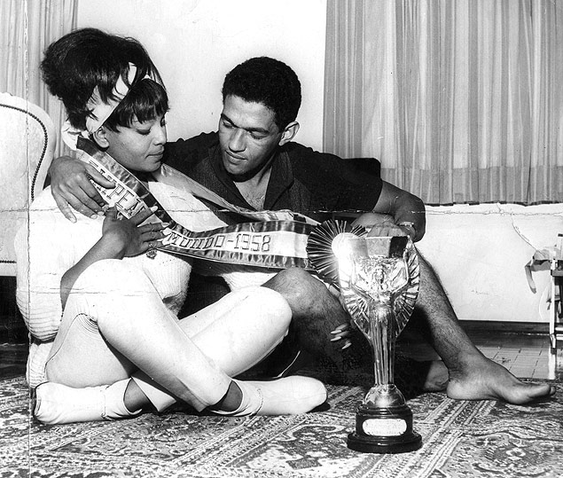 Garrincha e a cantora Elza Soares posam para foto com faixa de campeo da Copa de 1958 e a taa Jules Rimet