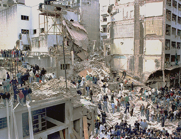Equipe de resgate trabalha sobre escombros do prédio destruído no atentado, em 1994