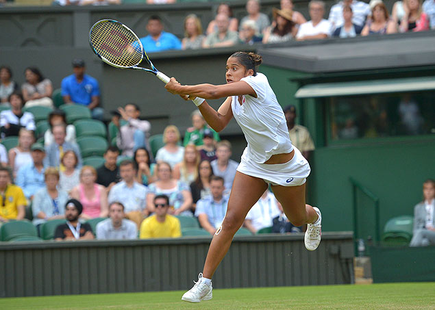 A tenista brasileira Teliana Pereira devolve bola contra a romena Simona Halep, em Wimbledon