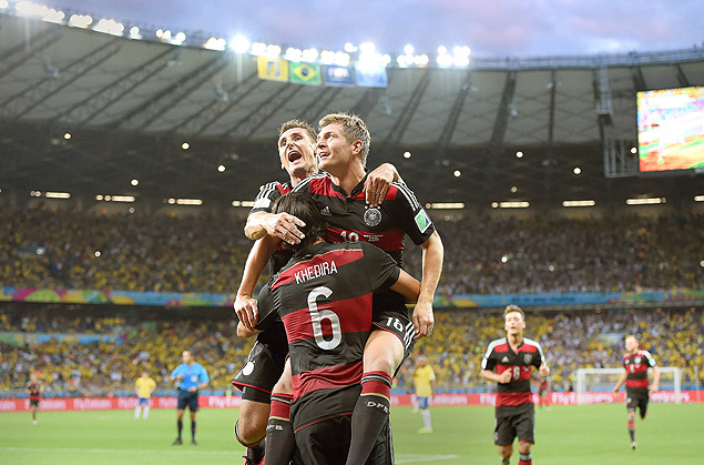 NIC. Belo Horizonte (Brazil), 08/07/2014.- Germany's Toni Kroos (R) celebrates with his teammates Miroslav Klose (L) and Sami Khedira (bottom) after scoring a goal during the FIFA World Cup 2014 semi final match between Brazil and Germany at the Estadio Mineirao in Belo Horizonte, Brazil, 08 July 2014. (RESTRICTIONS APPLY: Editorial Use Only, not used in association with any commercial entity - Images must not be used in any form of alert service or push service of any kind including via mobile alert services, downloads to mobile devices or MMS messaging - Images must appear as still images and must not emulate match action video footage - No alteration is made to, and no text or image is superimposed over, any published image which: (a) intentionally obscures or removes a sponsor identification image; or (b) adds or overlays the commercial identification of any third party which is not officially associated with the FIFA World Cup) (Brasil, Alemania, Mundial de Ftbol) EFE/EPA/MARCUS BRANDT EDITORIAL USE ONLY ORG XMIT: nic