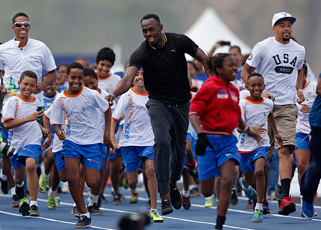 O jamaicano Usain Bolt corre com crianas no Rio de Janeiro