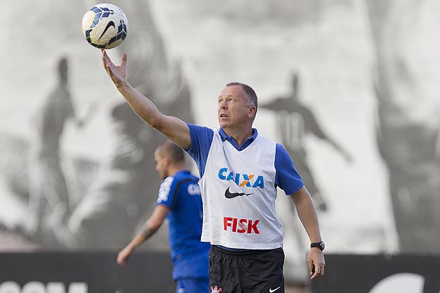 Mano Menezes tenta segurar a bola durante treino do Corinthians