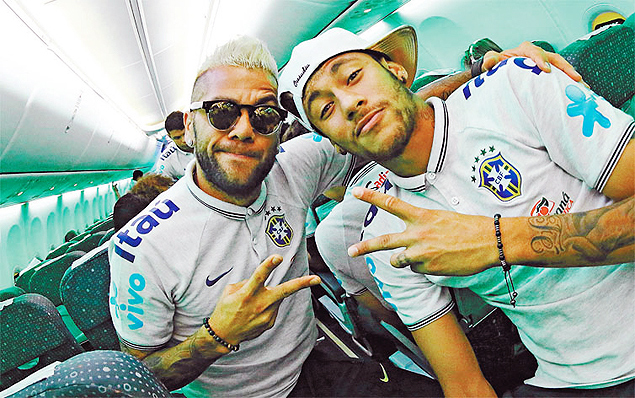 Daniel Alves e Neymar, com brincos e bonés, durante viagem da seleção na Copa