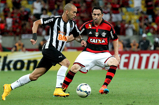 Diego Tardelli conduz a bola observado por Chico, do Flamengo