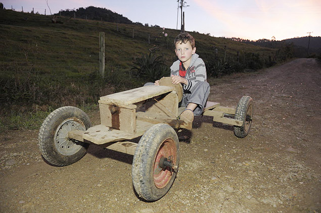 Leandro Beninca, 10, posa com o carrinho de madeira em Rio do Campo, no interior de Santa Catarina