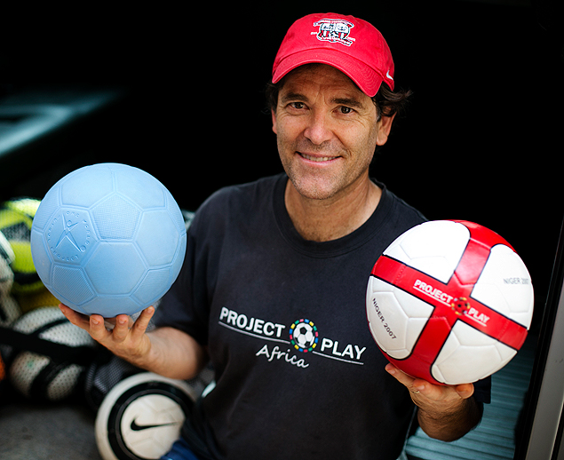 Mike Mitchell posa com a bola azul, enviada para ajudar o futebol de Nger, na frica