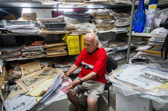 Jos Acras, 86, consulta acervo particular com jornais, revistas e livros sobre futebol