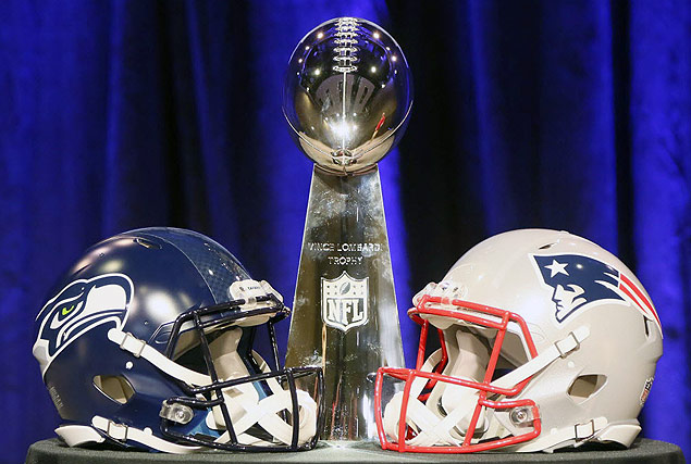 Capacetes do Seattle Seahawks e do New England Patriots ao lado do trofu do Super Bowl
