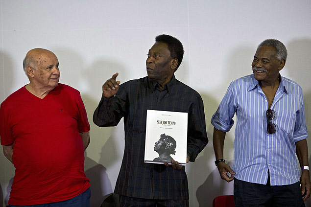 Brazilian football legend Edson Arantes do Nascimento, known as "Pele" (C), speaks next to former teammates Pepe (L) and Coutinho (R), during the autograph ceremony of his book "Segundo Tempo" (Second Half), in Santos, some 70 km from Sao Paulo, Brazil, on March 12, 2015. AFP PHOTO / NELSON ALMEIDA ORG XMIT: SAO011
