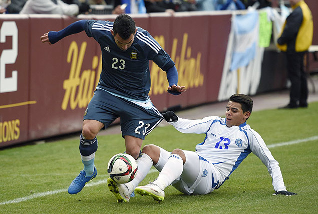 El Salvador's Alexander Larin (13) pulls on the shorts of Carlos Tevez (23) during the first half of an international friendly, Saturday, March 28, 2015, in Landover, Md. (AP Photo/Nick Wass) ORG XMIT: FDX102