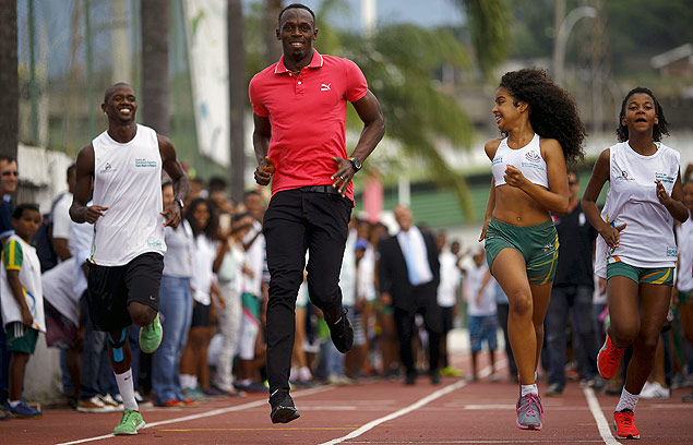 O velocista Usain Bolt corre com jovens na Vila Olmpica da Mangueira, no Rio