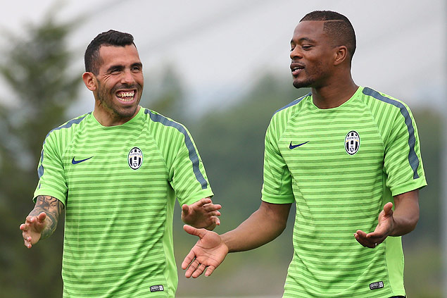 Tevez (esq.) e Evra conversam durante treino da Juventus para partida contra o Real Madrid