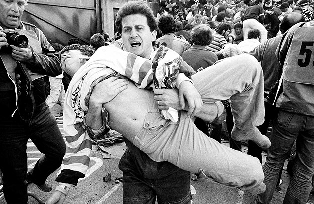 Homem carrega um torcedor machucado durante tragdia de Heysel, que envolveu hooligans ingleses