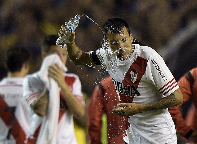 Leonel Vangioni, do River Plate, lava o rosto depois de ser atingido por g�s de pimenta dentro de campo
