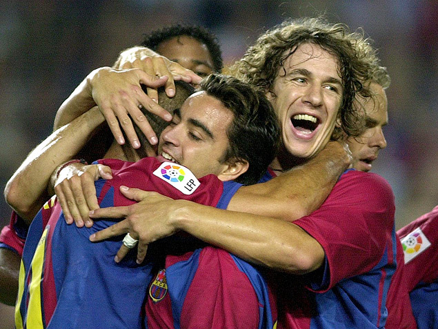 Xavi (centro) e Puyol (dir.) comemoram gol pelo Barcelona