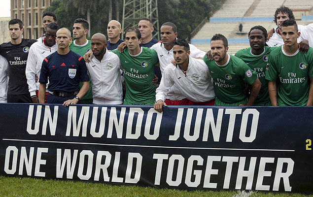 Jogadores de Cuba e do Cosmos (de verde) posam com faixa com os dizeres "um mundo unido" antes do amistoso 