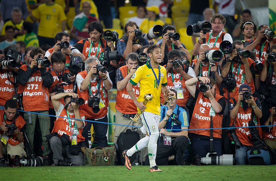 Carregando trofus, Neymar passa em frente a fotgrafos ao final da deciso da Copa das Confederaes