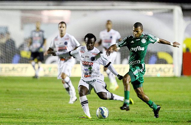 O volante Amaral (dir.), do Palmeiras, tenta tomar uma bola contra o ASA