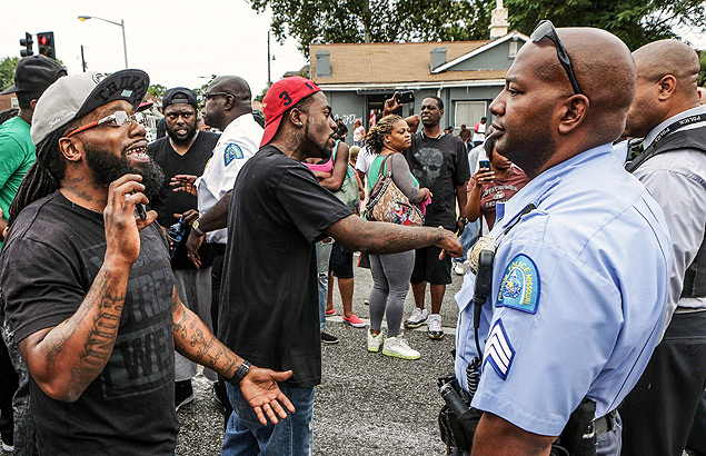 Manifestantes fala com policial durante protestos por morte de jovem negro em Saint Louis