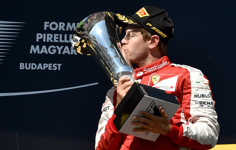 TOPSHOTS Ferrari's German driver Sebastian Vettel kisses the trophy as he celebrates on the podium winning the Hungarian Formula One Grand Prix at the Hungaroring circuit near Budapest on July 26, 2015. AFP PHOTO / ANDREJ ISAKOVIC ORG XMIT: 5698