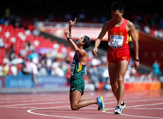 Caio Bonfim of Brazil (L) kneels at the finish line as Cai Zelin of China walks past after the men's 20 km race walk final at the 15th IAAF World Championships at the National Stadium in Beijing, China August 23, 2015. REUTERS/Lucy Nicholson ORG XMIT: CN21