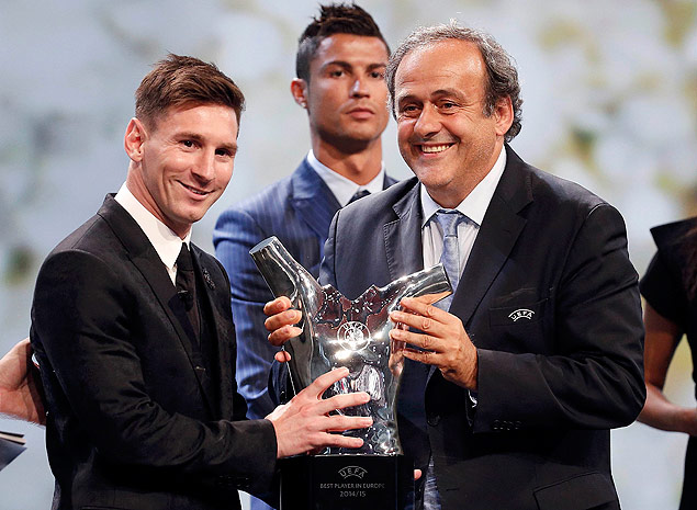Barcelona's Lionel Messi (L) receives from UEFA President Michel Platini the Best Player UEFA 2015 Award during the draw ceremony for the 2015/2016 Champions League Cup soccer competition at Monaco's Grimaldi Forum while Cristiano Ronaldo (C) looks on in Monte Carlo August 27, 2015. REUTERS/Eric Gaillard ORG XMIT: MCO01