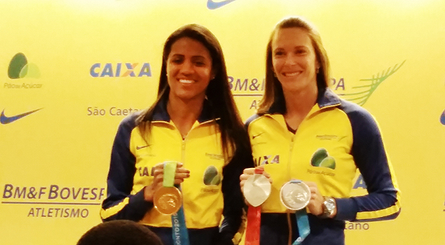 Juliana Gomes dos Santos e Fabiana Murer posa com as medalhas do Pan e do Mundial, respectivamente, em evento na Bolsa de Valores