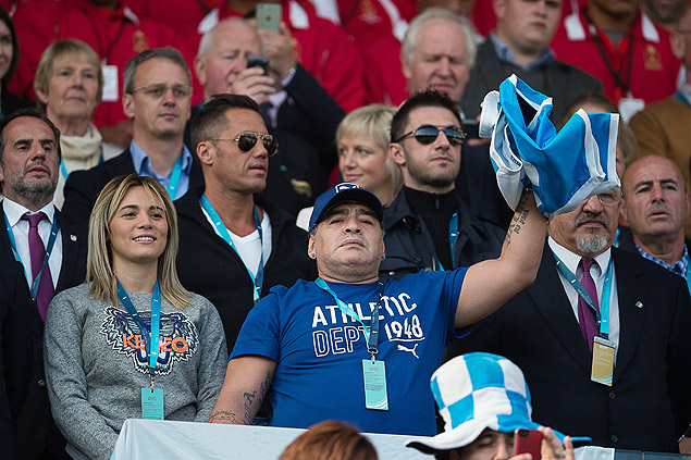 TOPSHOTS Former Argentina football international Diego Maradona (C) waves a flag before a Pool C match of the 2015 Rugby World Cup between Argentina and Tonga at Leicester City Stadium in Leicester, central England, on October 4, 2015. AFP PHOTO / BERTRAND LANGLOIS RESTRICTED TO EDITORIAL USE, NO USE IN LIVE MATCH TRACKING SERVICES, TO BE USED AS NON-SEQUENTIAL STILLS ORG XMIT: BL4506