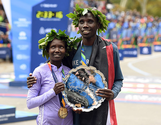 Mary Keitany (esq.) e Stanley Biwott, ambos do Qunia, comemoram vitria na maratona de Nova York