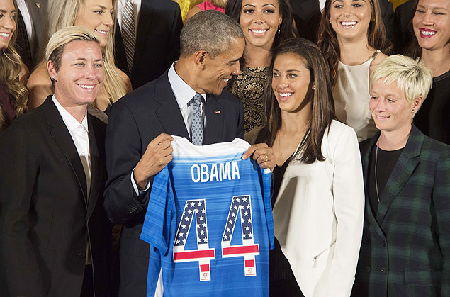 The US 2015 Women's World Cup Team's Abby Wambach (L) and Carli Lloyd (2nd R) present US President Barack Obama (C) with a team jersey during an event honoring them at the White House in Washington, DC, October 27, 2015. AFP PHOTO / JIM WATSON ORG XMIT: JIM001