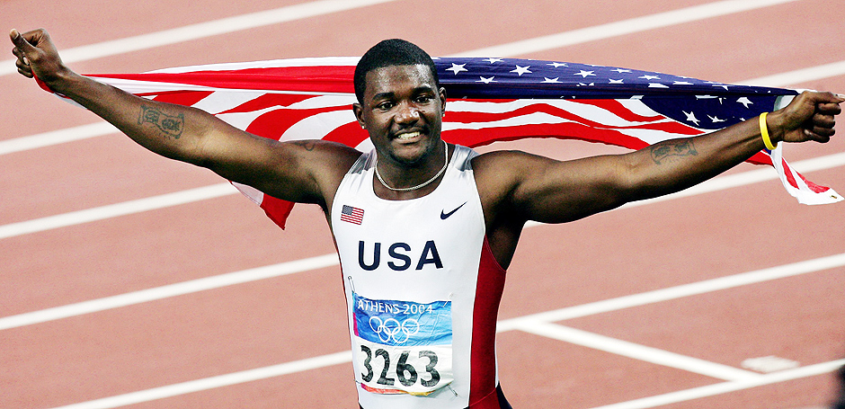 ORG XMIT: 283501_0.tif Usa's Justin Gatlin celebrates with his country's flag after winning the men's 100m final at the Olympic Stadium 22 August 2004. Usa's Justin Gatlin won the men's 100 metres Olympic title. The 22-year-old posted a personal best time of 9.85 seconds to beat Francis Obikwelu of Portugal, who timed a European record of 9.86sec, while 2000 Olympic champion Maurice Greene was third in a season's best 9.87sec.AFP PHOTO FRANCOIS XAVIER MARIT 