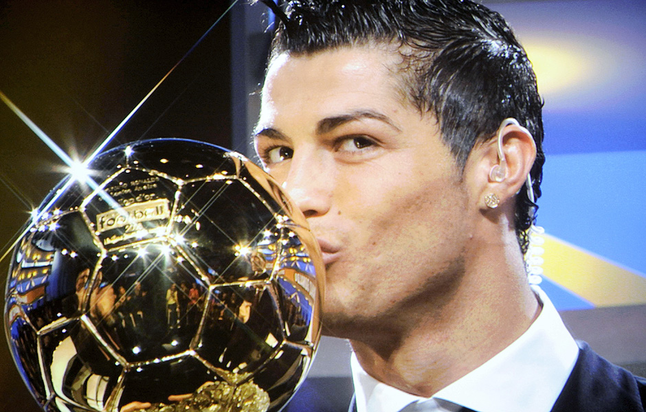 ORG XMIT: 542601_1.tif O jogador portugus Cristiano Ronaldo beija o trofu Bola de Ouro que recebeu em Paris (Frana). A photo taken on a TV screen shows Manchester United Portuguese winger Cristiano Ronaldo kissing his trophy on a French TV set after he won the European footballer of the year award, the "Ballon d'Or" (Golden ball), on December 7, 2008 in Boulogne-Billancourt, outside Paris. Ronaldo beat Barcelona's Lionel Messi and Liverpool striker Fernando Torres to the honour on the back of a phenomenal 2007-08 season in which he scored 42 goals for his Premier League and Champions League-winning club. Ronaldo becomes the first United player to win the award since the late George Best in 1968. AFP PHOTO FRANCK FIFE 