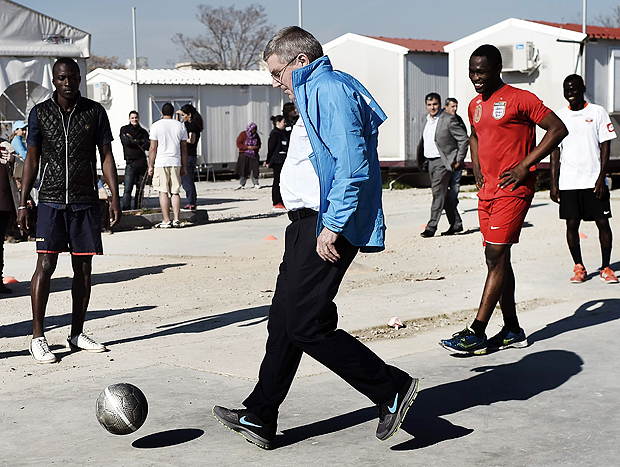 International Olympic Committee chairman Thomas Bach plays football with youths during a visit to the Elaionas camp for migrants and refugees in Athens on January 28, 2016. The facility accommodates hundreds of people from war-torn or impoverished nations who have not been allowed to continue their journey to northern Europe. The IOC in September announced an emergency two-million-dollar fund for refugee programmes. / AFP / ARIS MESSINIS ORG XMIT: ARIS2211