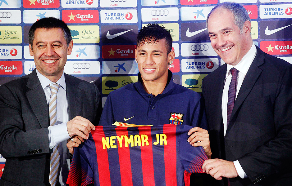 Brazilian soccer player Neymar (C) poses with his new jersey next to sports director Andoni Zubizarreta (R) and vice-president Ferran Bartomeu (L) after signing a five-year contract in Barcelona June 3, 2013. REUTERS/Albert Gea (SPAIN - Tags: SPORT SOCCER) ORG XMIT: BAR131
