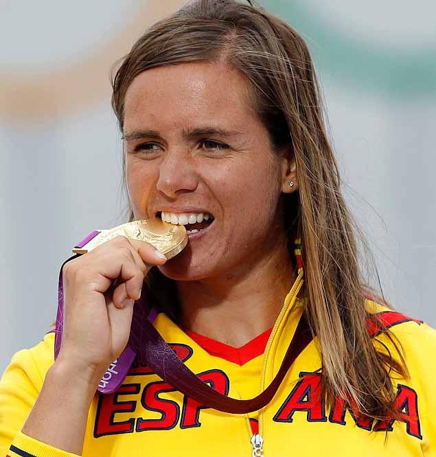 ORG XMIT: BTE31 Spain's Marina Alabau bites her gold medal for the women's RS-X sailing class during the victory ceremony at the London 2012 Olympic Games in Weymouth and Portland, southern England, August 7, 2012. REUTERS/Benoit Tessier (BRITAIN - Tags: SPORT YACHTING OLYMPICS)