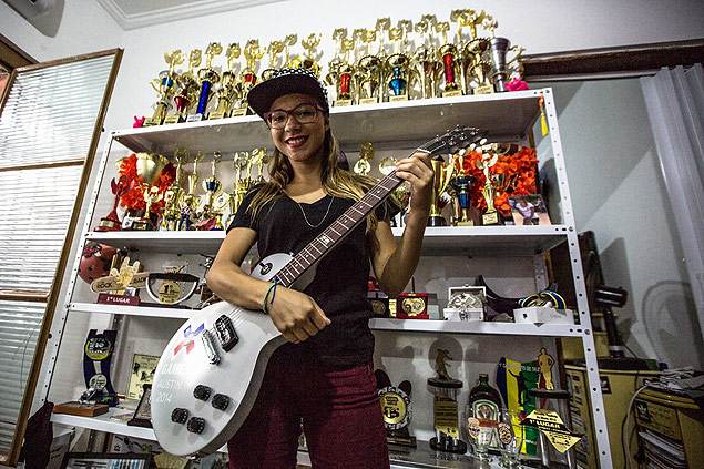 A skatista Pamela Rosa exibe uma guitarra e seus trofus