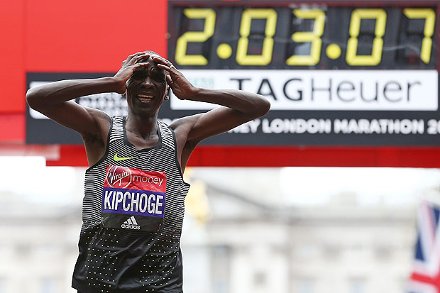 TOPSHOT - Kenya's Eliud Kipchoge reacts after crossing the finish line to win the elite men's race of the 2016 London Marathon in central London on April 24, 2016. Eliud Kipchoge of Kenya set a new course record in winning the London Marathon for the second straight year on Sunday. The former track star clocked an unofficial time of 2hrs 03mins 05secs, just eight seconds shy of the world record set by fellow Kenyan Dennis Kimetto at the Berlin Marathon in September 2014. / AFP PHOTO / JUSTIN TALLIS