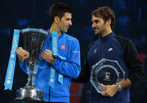 Serbia's Novak Djokovic (L) holds the ATP trophy with runner up Switzerland's Roger Federer after winning the men's singles final match against on day eight of the ATP World Tour Finals tennis tournament in London on November 22, 2015. AFP PHOTO / GLYN KIRK ORG XMIT: 718
