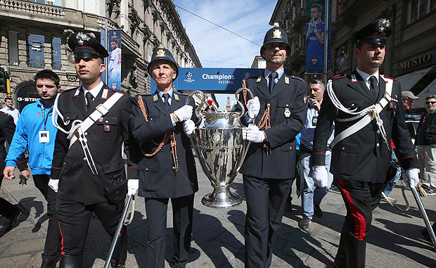 Police officers carried the Champions League trophy during the Champions Festival in Milan. Credit Luca Bruno/Associated Press 