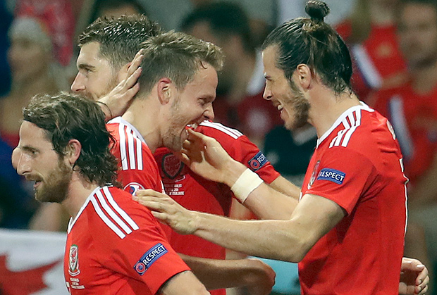Wales' Gareth Bale is congratulated by his teammates after scoring their third goal during the Euro 2016 Group B soccer match between Russia and Wales at the Stadium municipal in Toulouse, France, Monday, June 20, 2016. (AP Photo/Petr David Josek) ORG XMIT: FOS140