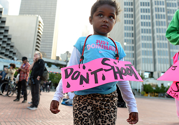 Criana exibe cartaz com dizeres 'no atire' durante protesto do Black Lives Matter em San Francisco