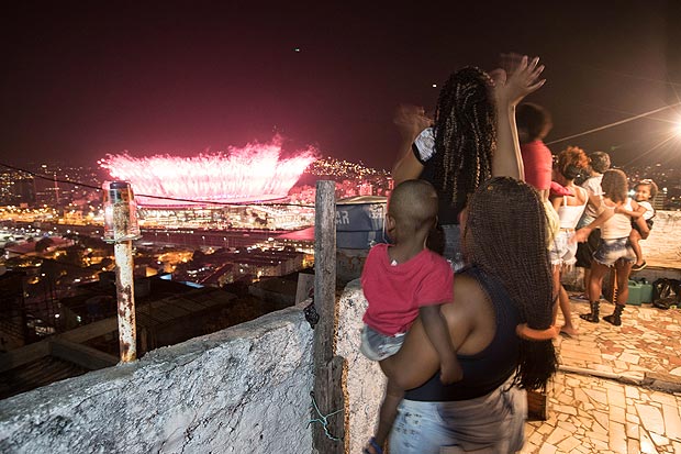 Vecinos del morro da Mangueira miran los fuegos artificiales que explotan en el estadio Maracan