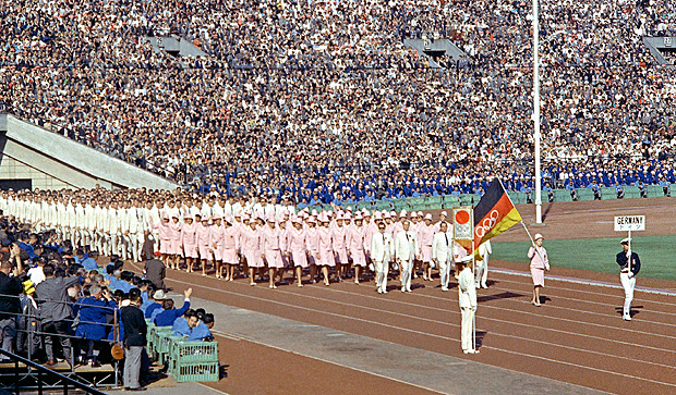 FILE - In this Oct. 10, 1964, file photo, the United Team of Germany enters the Olympic Stadium at the opening ceremony of the Summer Olympic Games in Tokyo, Japan. While Germany was a divided country, West Germany and East Germany, from 1956 to 1964, came together and participated at the Olympics as the Unified Team of Germany. The team's Olympic flag looked like the German flag, except with white Olympic rings in the middle. (AP Photo/File) ORG XMIT: NY156