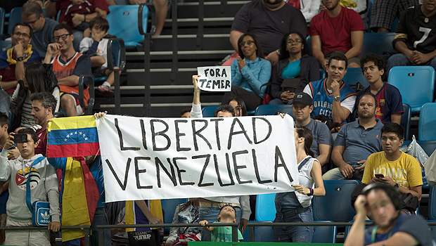 Cartaz exibido durante partida de basquete masculino entre EUA e Venezuela