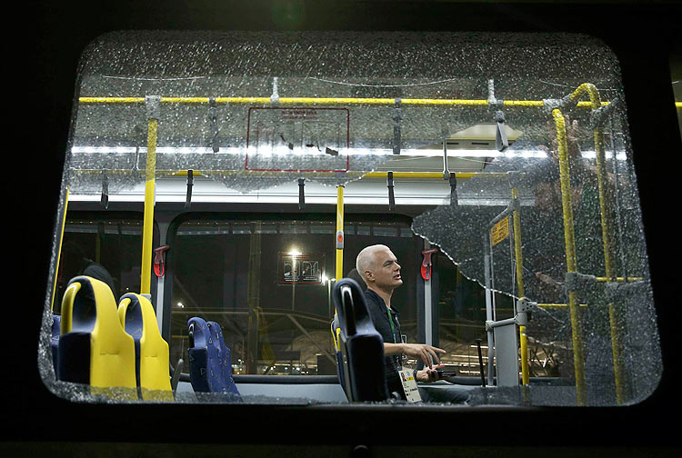 A person sits on an official media bus after a window shattered when driving accredited journalists to the Main Transport Mall from the Deodoro venue of the Rio 2016 Olympic Games in Rio de Janeiro, August 9, 2016. REUTERS/Shannon Stapleton ORG XMIT: SRR122