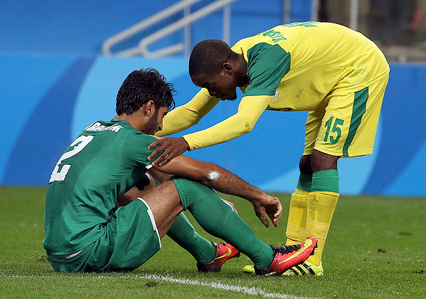 2016 Rio Olympics - Soccer - Preliminary - Men's First Round - Group A South Africa v Iraq - Corinthians Arena - Sao Paulo, Brazil - 10/08/2016. Phumlani Ntshangase (RSA) of South Africa comforts Ibrahim Ahmed (IRQ) of Iraq after the match. REUTERS/Paulo Whitaker FOR EDITORIAL USE ONLY. NOT FOR SALE FOR MARKETING OR ADVERTISING CAMPAIGNS. ORG XMIT: KAT1065