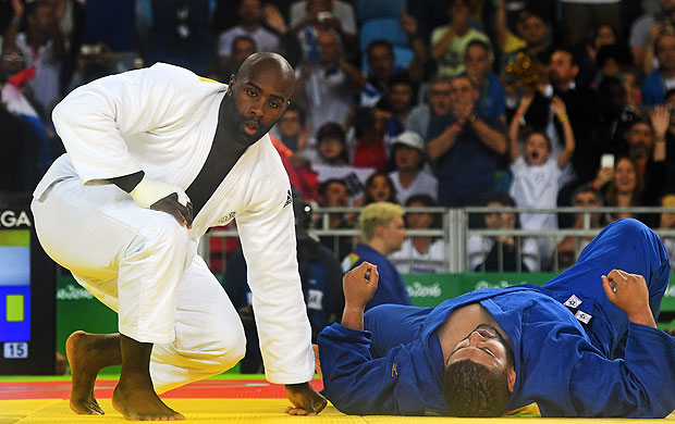 France's Teddy Riner (white) competes with Algeria's Mohammed Amine Tayeb during their men's +100kg judo contest match of the Rio 2016 Olympic Games in Rio de Janeiro on August 12, 2016. / AFP PHOTO / Toshifumi KITAMURA