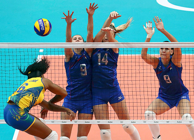 2016 Rio Olympics - Women's Preliminary - Pool A Brazil v Russia - Maracanazinho - Rio de Janeiro, Brazil - 14/08/2016. Fernanda Rodrigues (BRA) of Brazil (L) spikes the ball against (L-R) Vera Vetrova (RUS) of Russia, Irina Fetisova (RUS) of Russia and Natalya Goncharova (RUS) of Russia. REUTERS/Yves Herman FOR EDITORIAL USE ONLY. NOT FOR SALE FOR MARKETING OR ADVERTISING CAMPAIGNS. ORG XMIT: DBA169