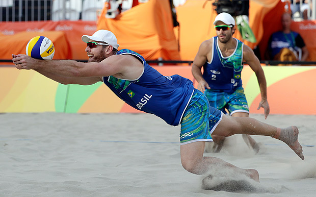 Brazil's Alison Cerutti, left, digs in front of teammate Bruno Oscar Schmidt against the United States during a men's beach volleyball quarterfinal match at the 2016 Summer Olympics in Rio de Janeiro, Brazil, Monday, Aug. 15, 2016. (AP Photo/Marcio Jose Sanchez) ORG XMIT: OBVL203